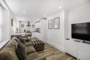a living room with a couch and a flat screen tv at NEW Stunning Plymouth Central Apartment - Sleeps 6 in Plymouth
