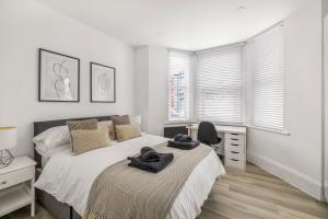 a bedroom with a bed and a desk and windows at NEW Stunning Plymouth Central Apartment - Sleeps 6 in Plymouth