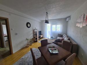 een woonkamer met een tafel en een bank bij Sirob bubanj in Kragujevac