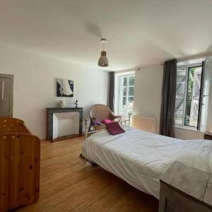 1 dormitorio con 1 cama grande y chimenea en Maison gîte tranquille et nature., en Verdun-en-Lauragais