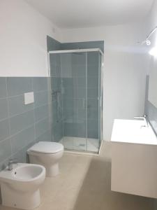 a bathroom with a shower and a toilet and a sink at Sorgenti nel bosco Appartamento vista lago in Campo Reggiano