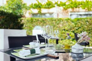 a black table with glasses and plates on it at Le Carré d'Alethius Logis Hôtel Restaurant in Charmes-sur-Rhône