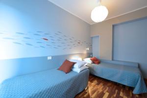 2 Betten in einem Zimmer mit einem Fischbild an der Wand in der Unterkunft Hotel Bristol in Alassio