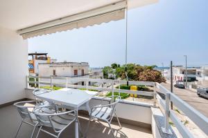 un tavolo bianco e sedie su un balcone con vista di Casa vacanze Pescoluse a Marina di Pescoluse