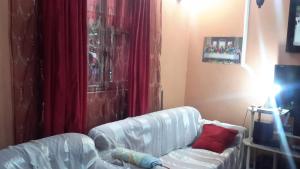 a living room with a couch and a red curtain at Birhan Villa in Addis Ababa