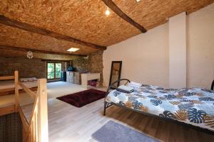 1 dormitorio con 1 cama y suelo de madera en La Maison Occitane - Charmante maison pour 4, en Caunes-Minervois