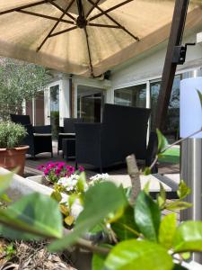 a patio with chairs and an umbrella at Bed & Breakfast La Rondinella in Cerasolo