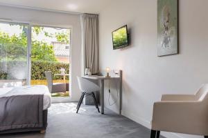 TV a/nebo společenská místnost v ubytování Le Carré d'Alethius Logis Hôtel Restaurant