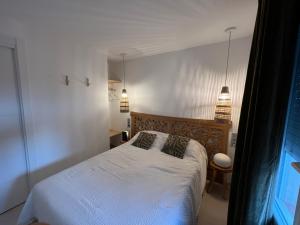 a bedroom with a white bed with two pillows at Almadrava Paradise in Roses