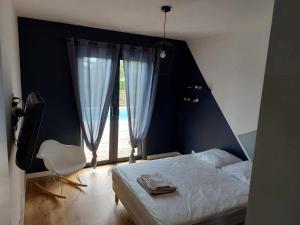 a bedroom with a bed and a chair and a window at Villa T4 avec piscine in Lucciana