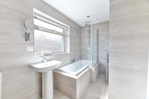 a bathroom with a sink and a bath tub at Properties Unique Dene Rooms - Family Room in Newcastle upon Tyne