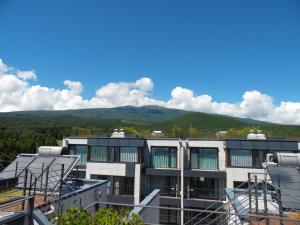 a view of a building with mountains in the background at Healthcare Town Resort in Seogwipo