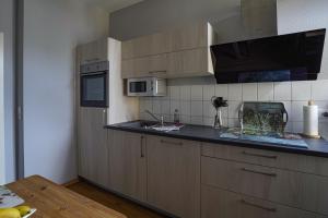 uma cozinha com armários de madeira e uma bancada em Abendsonne em Naumburg