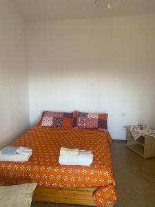 an orange bed with towels on it in a room at Far from the Madding Crowd in Barcelona