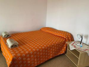 uma cama laranja num quarto com uma mesa lateral em Far from the Madding Crowd em Barcelona