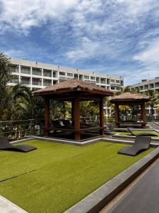 un kiosque avec des chaises et de la pelouse devant un bâtiment dans l'établissement MALDIVES (Laguna Beach Resort 3), à Jomtien Beach