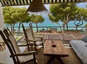 uma sala de estar com mesa e cadeiras e vista para o oceano em Almadrava Paradise em Roses