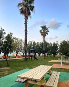 a picnic table in a park with palm trees at la casetta di Sophia in Torrenova