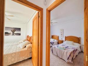 a bedroom with two beds and a mirror at Valencia Sol y Playa in Sagunto