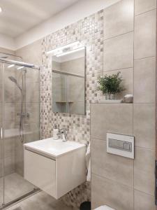 een badkamer met een wastafel en een douche bij Paskom Apartmanház in Nyergesújfalu