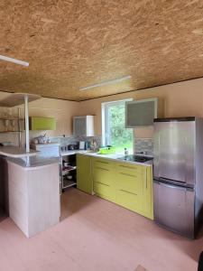 a large kitchen with yellow and silver appliances at Liafa laikas 