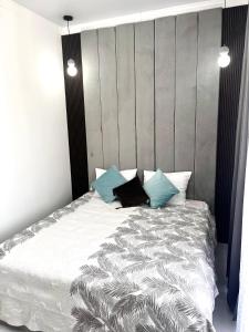 ein Schlafzimmer mit einem großen weißen Bett mit blauen Kissen in der Unterkunft Grand champion apartments in Taldykolʼ