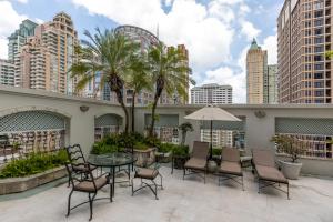 a patio with a table and chairs and buildings at Cape House Langsuan Hotel in Bangkok