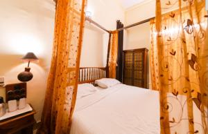 a bedroom with a wooden canopy bed with a window at Sisodia Hotel & Resorts in Jodhpur