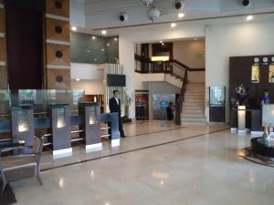 a lobby with a person standing in a building at Inn Riviera Jammu in Jammu