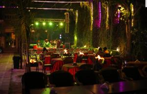 a group of people sitting at tables in a restaurant at Sisodia Hotel & Resorts in Jodhpur