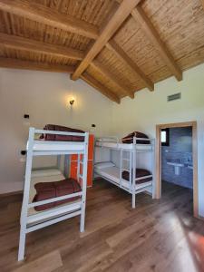 two bunk beds in a room with a wooden ceiling at Albergue Los Hospitales 