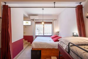 Un dormitorio con dos camas y una ventana. en MyTinyHome Festina Lente, en Roma