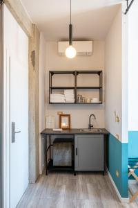 uma cozinha com uma secretária e um lavatório num quarto em MyTinyHome Festina Lente em Roma