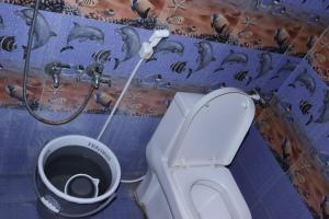 La salle de bains est pourvue de toilettes et d'un seau d'eau. dans l'établissement pondy Vibes 2bhk home Stay, à Pondichéry