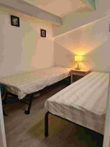 Zimmer mit 2 Betten und einer Lampe auf einem Tisch in der Unterkunft Cap d'agde VUE MER in Cap d'Agde