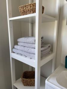 Un toallero blanco con toallas en el baño. en Proche Chambord - Gîte Cosy à l'Orée du Bois de St Cyr, en La Ferté-Saint-Cyr