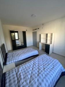 a large bedroom with two beds and a window at German-Palestinian Appartement in Al Khalīl