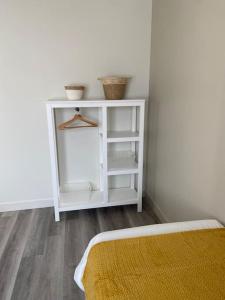 Un dormitorio con un armario blanco con dos cestas. en Proche Chambord - Gîte Cosy à l'Orée du Bois de St Cyr, en La Ferté-Saint-Cyr