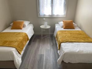 dos camas sentadas una al lado de la otra en una habitación en Proche Chambord - Gîte Cosy à l'Orée du Bois de St Cyr, en La Ferté-Saint-Cyr