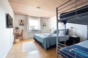 - une chambre avec des lits superposés et un bureau dans l'établissement Stone Mountain BnB, à Stenbjerg