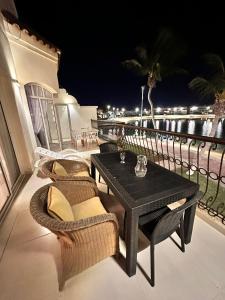 a table and chairs on a balcony with a view of the water at شاليه درة العروس in Durat Alarous