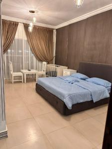 a bedroom with a bed and a table and chairs at شاليه درة العروس in Durat  Alarous
