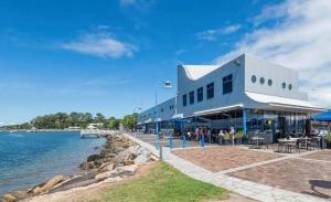 a large building next to a body of water at Coastal Cottage Batemans Bay in Batemans Bay