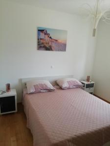 ein Schlafzimmer mit einem Bett und einem Bild an der Wand in der Unterkunft Apartment Silvana in Trogir