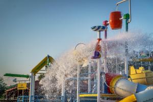 una fontana in un parco divertimenti con scivolo d'acqua di Hotel Kanali a Kanali