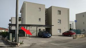 ein Auto, das auf einem Parkplatz neben einem Gebäude parkt in der Unterkunft Apartment Silvana in Trogir