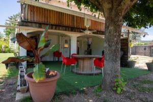 una casa con tavolo, sedie e un albero di Rez de Villa - Le Luc a Le Luc