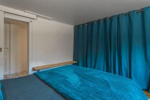 una camera da letto con un letto blu e tende blu di Rez de Villa - Le Luc a Le Luc