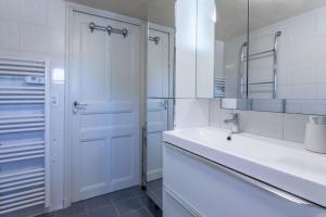 un bagno bianco con lavandino e specchio di Rez de Villa - Le Luc a Le Luc Altre 13 foto