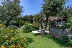 a garden with a bench and trees and flowers at Villa Olivia pool tennis spa - C in Lecce